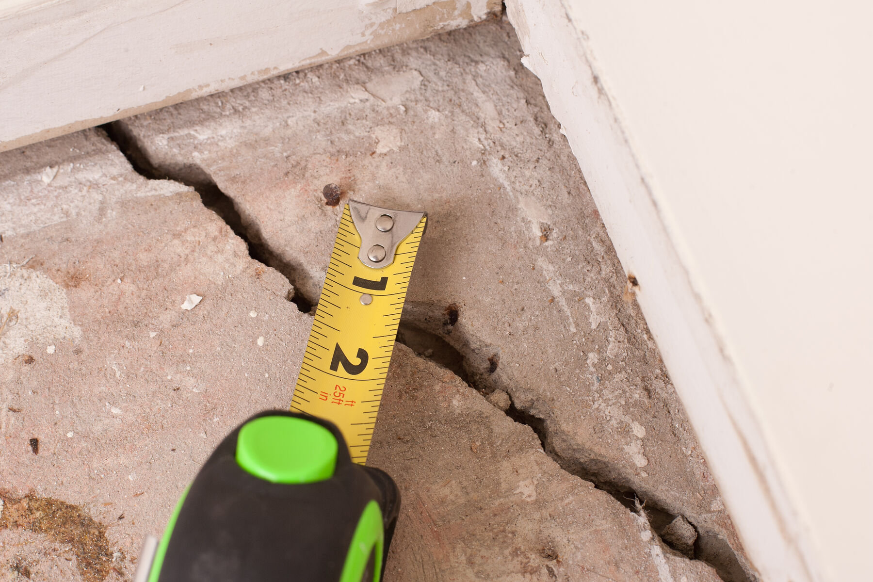 ruler measuring a cracked concrete floor