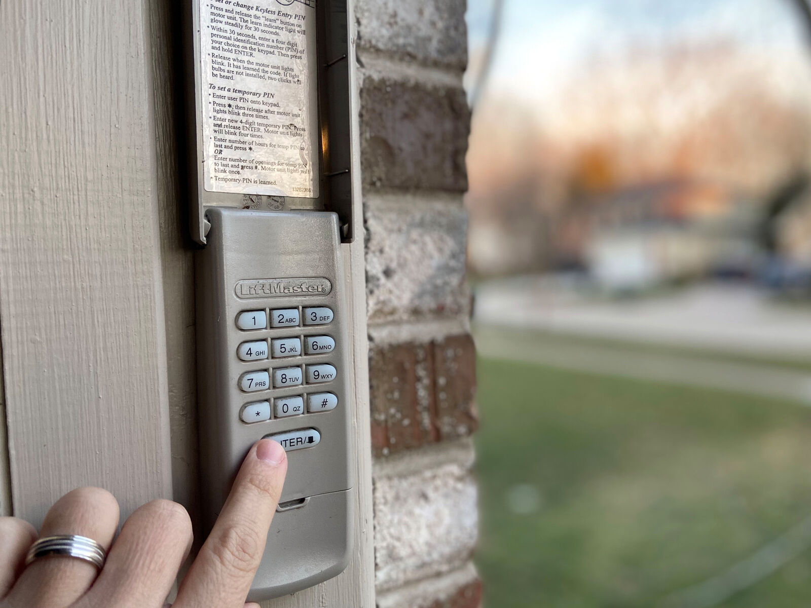 Garage door keypad mounted on a brick exterior