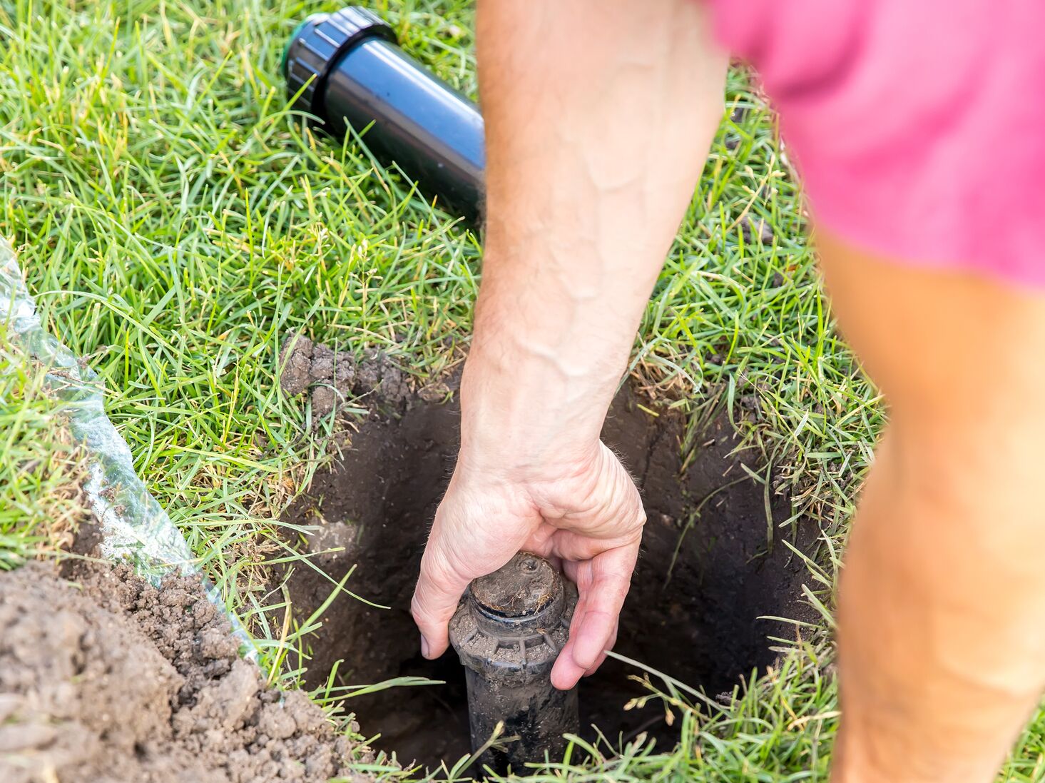 Man Replacing In Ground Spinkler Head